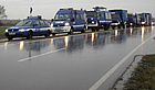 Acht blaue THW-Fahrzeuge stehen bei Regen auf dem Radweg zwischen Ottenheim und Nonnenweier bei einem technischen Halt