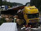 Mit Papierrollen beladener LKW liegt quer auf Mittelleitplanke der Autobahn A5